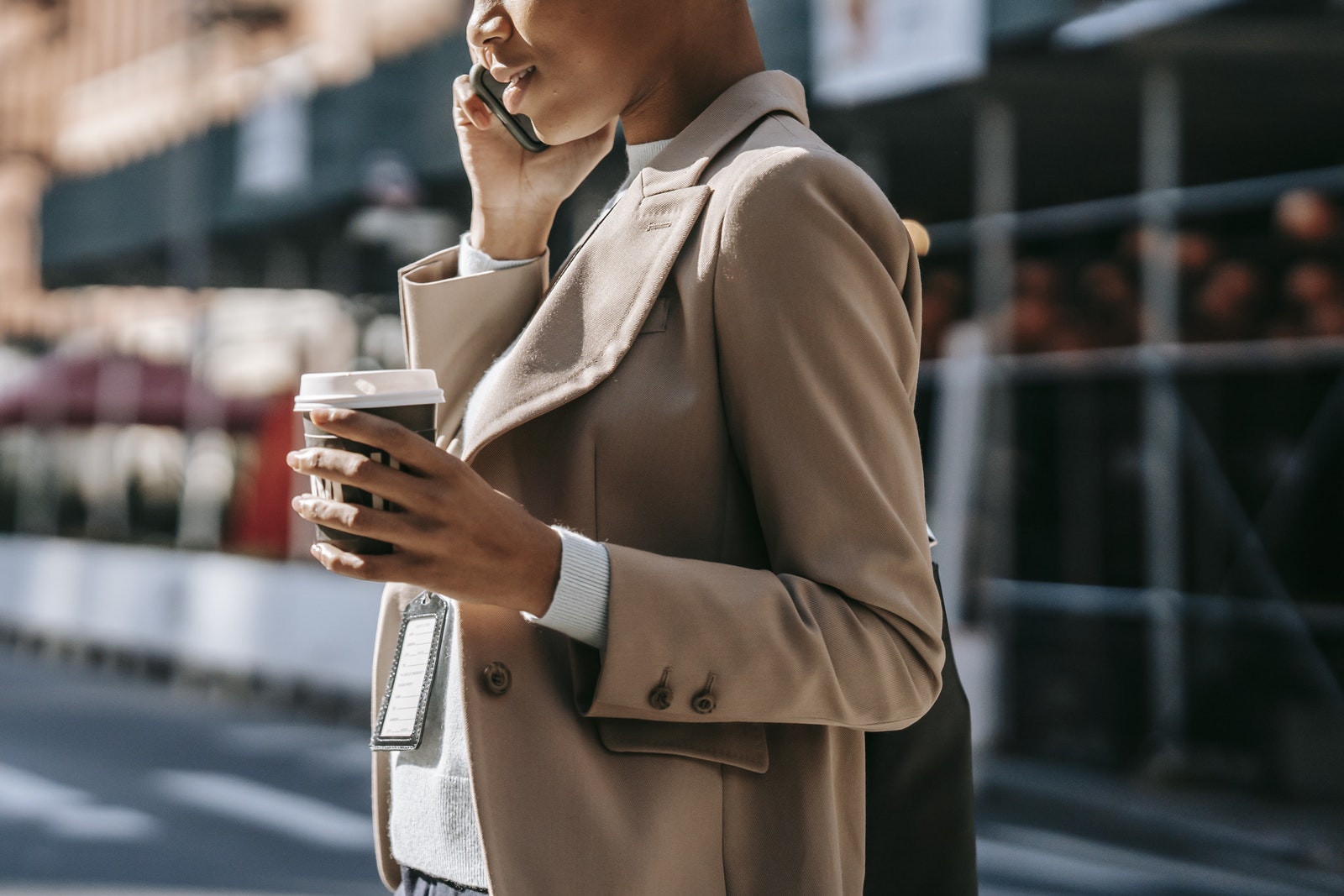 Crop black businesswoman speaking on smartphone on street